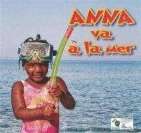 une petite fille est debout devant la mer, un masque sur le front et un tuba à l