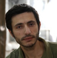 Portrait de Fadi Adleh avec un polo vert.
