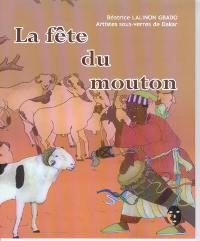 Au premier plan, un homme en tenue traditionnelle agite un bâton et joue du tambour devant un bélier blanc à tâches noires. En arrière plan, le reste du troupeau regarde la scène.