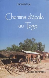 Des enfants devant des cabanes à un village africain.