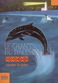 Un dauphin noir saute sur un fond d'eau bleu