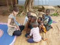 Dans la rue. Installés sur une natte, un groupe d’enfants suit la lecture d’un album par une animatrice. 