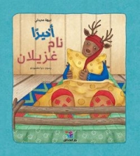 Un renne assis dans son lit sourit au lecteur. Couleurs vives.