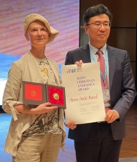 Marie-Aude Murail reçoit le prix Hans Christian Andersen des mains de Mingzhou Zhang, président d'IBBY