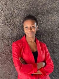 Femme adossée à un mur en veste rouge