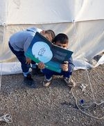 Province de Kermanshah après le tremblement de terre. Projet "Lis avec moi", Iran. Des enfants lisent devant une tente à Kermanshah, après le tremblement de terre.